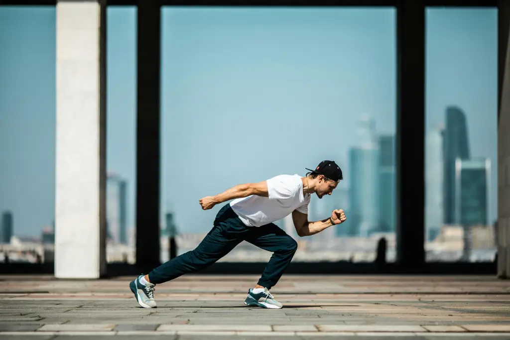 pexels-photo-4048182-4048182 Dynamic shot of a young man sprinting outdoors in an urban setting with skyscrapers in the background.